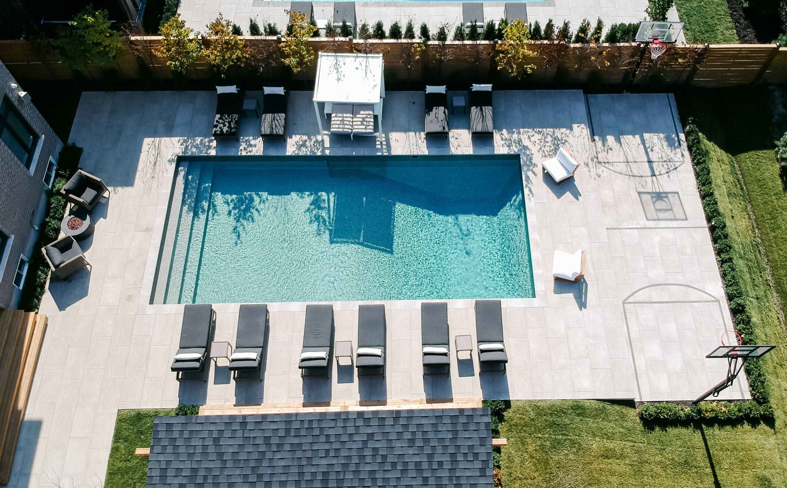 Aerial view of a full backyard transformation with pool and interlock