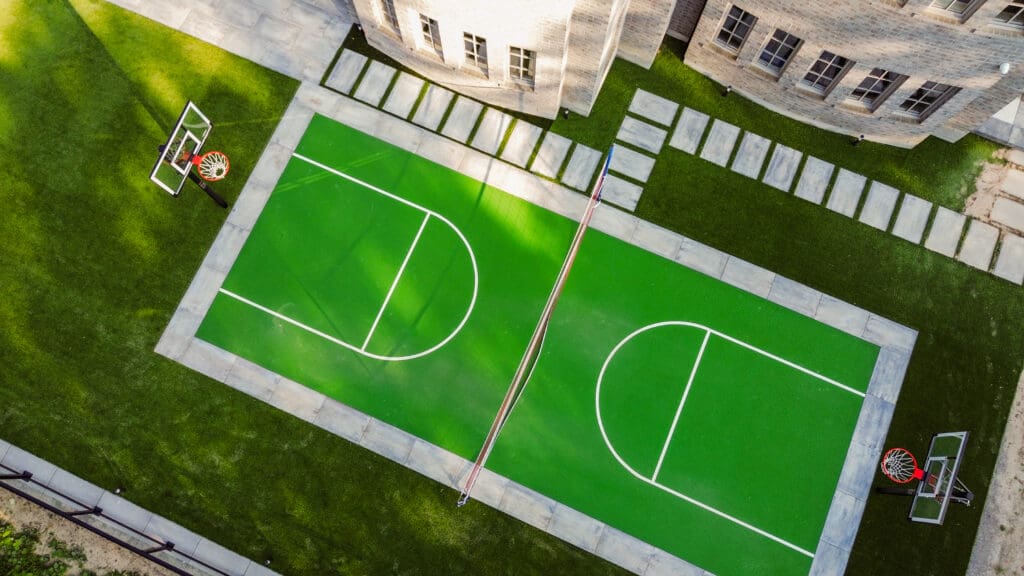 Aerial view of a backyard with sports court, turf and pavilion