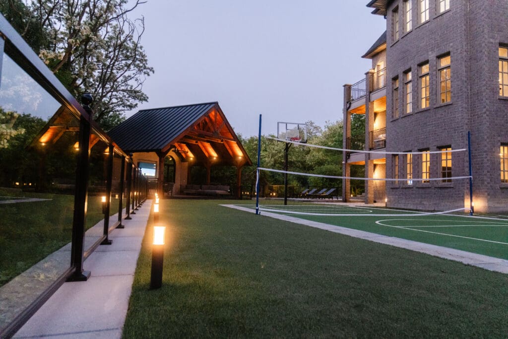 Backyard transformation with pavilion, lighting and walkway at dusk
